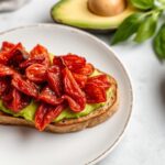 Sun-dried tomato avocado toast, a delicious and irresistible sun-kissed delight.